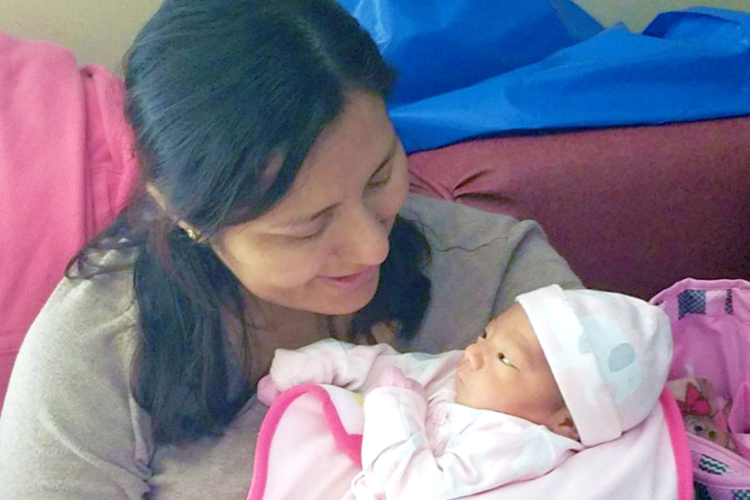Maria holding her newborn daughter Keily